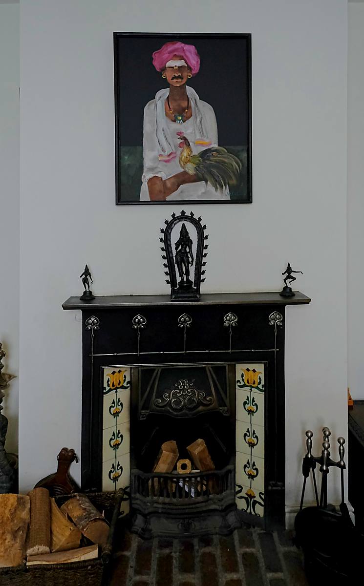 A tiled fireplace with a framed portrait above it