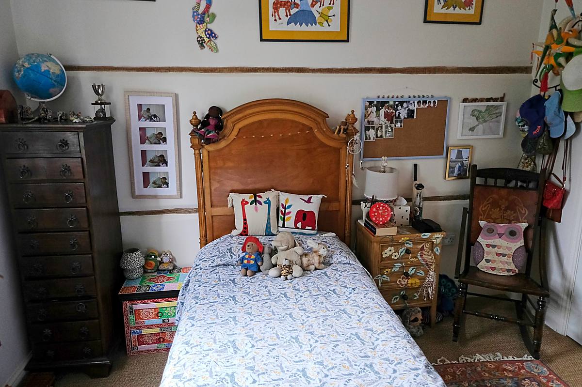A child&rsquo;s bedroom with a wooden bed and pictures on the walls